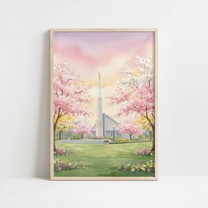 May include: Watercolor painting of a temple with a tall spire, set against a pink and yellow sky. Cherry blossom trees in full bloom frame the temple, with a green lawn and colorful flowers in the foreground. The artwork is in a wooden frame.
