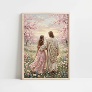 May include: A framed art print depicts two figures walking through a field of wildflowers and cherry blossom trees. One figure wears a flowing pink dress, the other a cream-colored robe. The artwork has a soft, pastel color palette and a serene, spiritual theme.