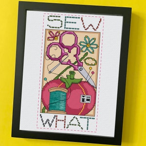 May include: Framed cross-stitch art with the words "SEW WHAT" in a stitched font. The artwork features a tomato with a spool of thread, scissors, needles, and other sewing-related elements in a colorful design.
