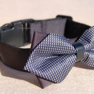 May include: A black dog collar with a silver buckle and a gray and black bow tie.