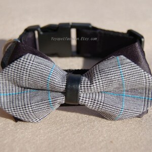 May include: A black dog collar with a gray and blue plaid bow tie. The collar has a black buckle and the text "Yoyopetfashion.Etsy.com" is printed on the collar.
