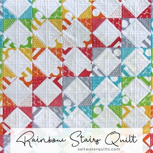 May include: A colourful quilt with a rainbow pattern and the text "Rainbow Stairs Quilt" and "saltwaterquilts.com".