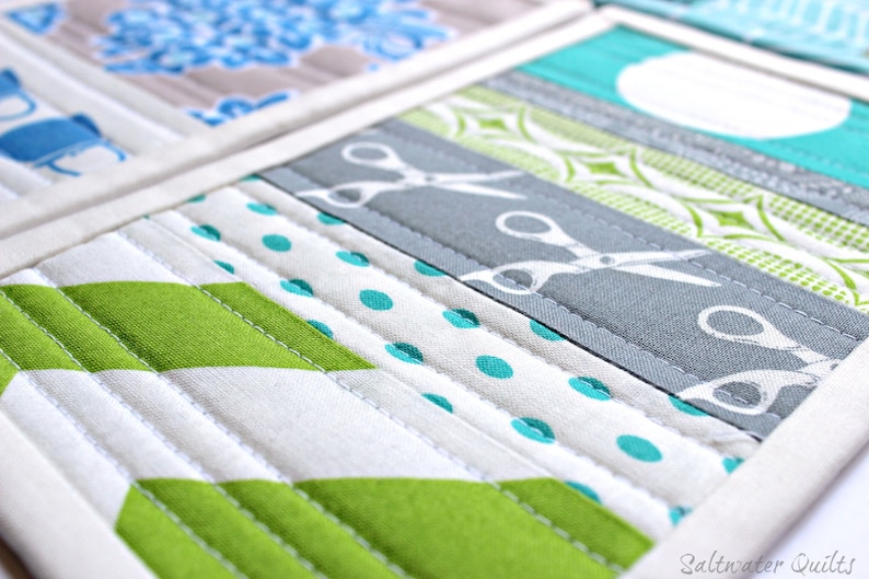May include: A quilted fabric piece featuring horizontal strips of various patterns including lime green chevrons, white fabric with teal polka dots, and a grey strip with a white scissor print. The text Saltwater Quilts is visible in the bottom right corner.