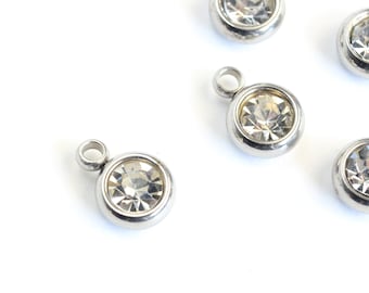 May include: Five silver-toned metal charms with clear crystal rhinestones. Each charm has a loop for attaching to a necklace or bracelet.