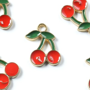 May include: Gold-tone metal charms shaped like cherries with red enamel and green enamel leaves.