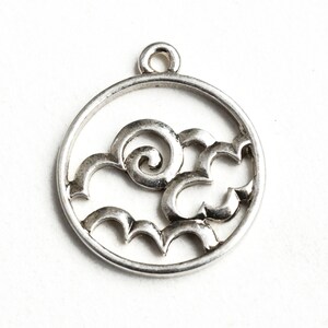 May include: Silver charm with a circular design featuring a stylized cloud with a swirl in the center.