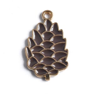 May include: A decorative pendant in the shape of a pine cone. The pendant has a dark brown enamel finish with gold-colored trim and a loop at the top for hanging. The pine cone design is detailed and realistic.