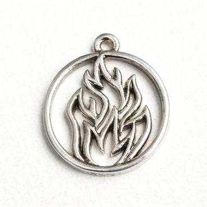 May include: Silver charm with a circular design featuring a stylized flame inside.