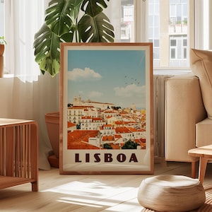 A framed poster of Lisbon, Portugal, displayed in a living room with a large window and a potted plant in the background.