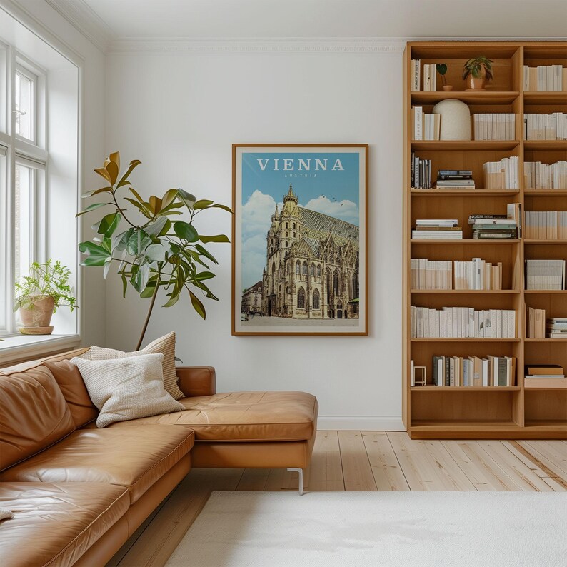 a cozy living room with a large bookshelf filled with books, a comfortable leather couch, and a framed poster of a cathedral in Vienna, Austria.