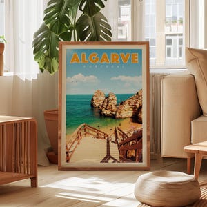 A framed poster of a beach scene in Algarve, Portugal, with a wooden staircase leading to the beach and palm trees in the background.
