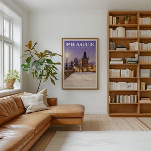 a cozy living room with a large bookshelf filled with books, a comfortable leather couch, and a framed poster of Prague in the background.