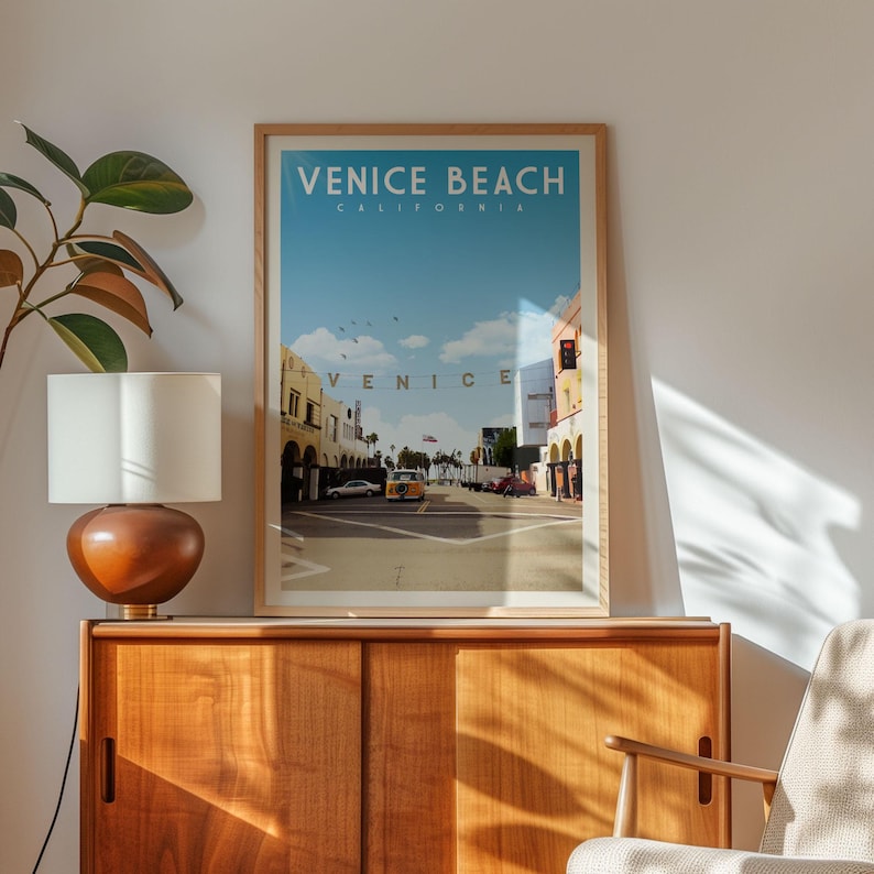 a framed poster of Venice Beach, California, with a vintage-style illustration of the city's streets and buildings.
