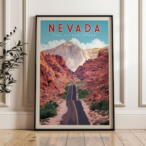 The image is a framed poster of a scenic road winding through a mountainous landscape, with the text "NEVADA THE SILVER STATE" prominently displayed.