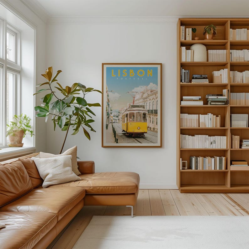 a cozy living room with a large bookshelf filled with books, a comfortable leather couch, and a framed poster of a yellow tram in Lisbon.