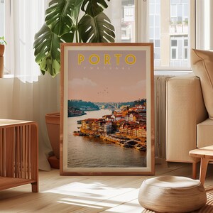 a framed poster of a scenic view of Porto, Portugal, with a river and buildings in the background.