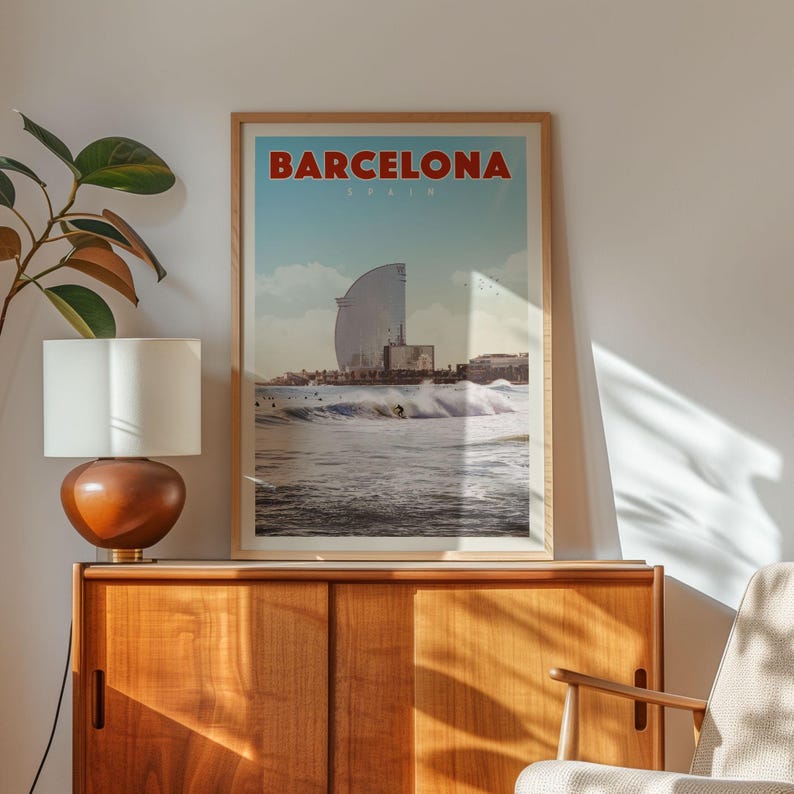a framed poster of Barcelona, Spain, hanging on a wall above a wooden cabinet.