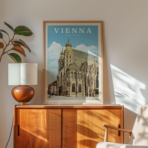 a framed poster of the St. Peter's Basilica in Vienna, Austria, displayed on a wooden cabinet.
