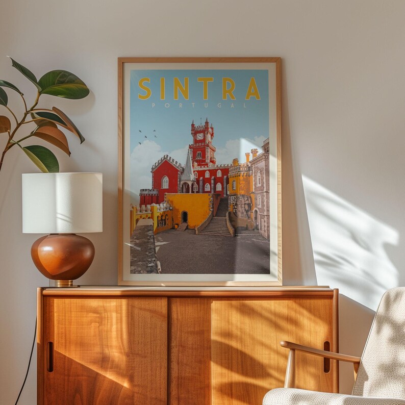 a framed poster of Sintra, a city in Portugal, hanging on a wall above a wooden cabinet.