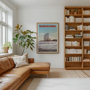 a cozy living room with a large bookshelf filled with books, a comfortable leather couch, and a framed poster of Barcelona hanging on the wall.