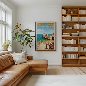 a cozy living room with a large bookshelf filled with books, a comfortable leather couch, and a framed poster of a beach scene hanging on the wall.