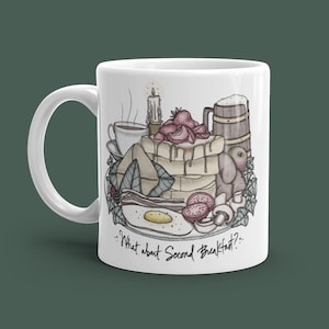 Peut inclure: Une tasse en céramique blanche avec une illustration dessinée à la main d'un petit-déjeuner, comprenant des œufs, du bacon, des toasts, des fraises et une chope de bière. Le texte "...What about Second Breakfast? ..." est imprimé sur la tasse.