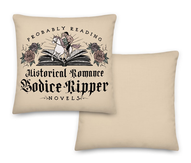 May include: Beige throw pillow featuring a black and white illustration of a person riding a horse on top of an open book. The text "Probably Reading Historical Romance Bodice Ripper Novels" is printed on the pillow.