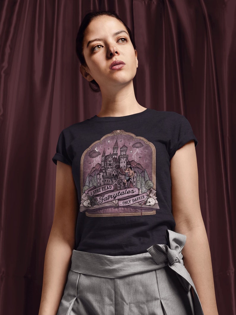 Puede incluir: Una camiseta negra con un gr&aacute;fico de un castillo y el texto "I still read fairytales... only darker".