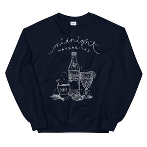 May include: Navy blue sweatshirt with a white graphic design of a bottle of tequila, a mortar and pestle, a lime, and a glass with a lime wedge. The text "midnight margaritas" is written in a cursive font above the graphic.