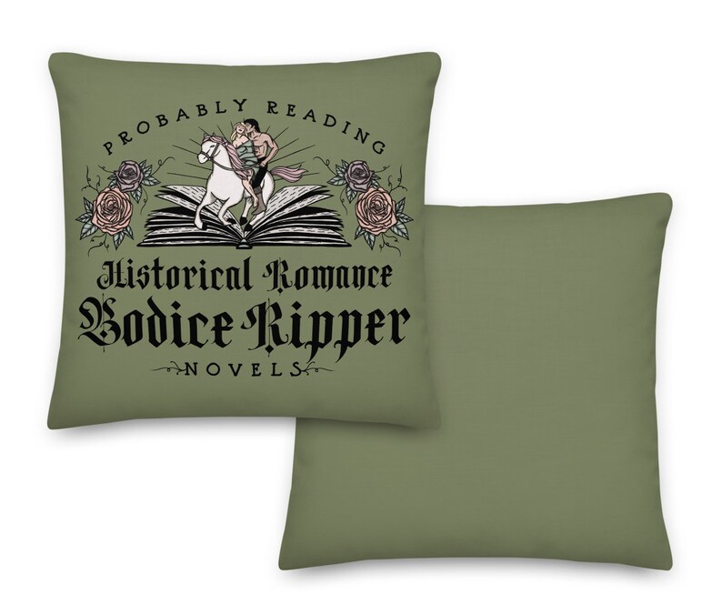 May include: Two green throw pillows, one with a graphic of a couple riding a horse on a book with the text "Probably Reading Historical Romance Bodice Ripper Novels" and the other plain.