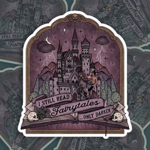 Peut inclure: Un autocollant avec un fond violet foncé représentant un château, un couple à cheval et un livre avec le texte "I Still Read Fairytales...Only Darker".