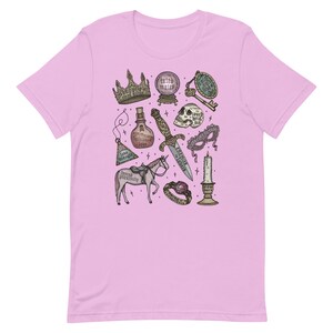K&ouml;nnte beinhalten: Ein pinkfarbenes T-Shirt mit einem grafischen Druck verschiedener magischer Gegenst&auml;nde, darunter eine Krone, eine Zaubertrankflasche, ein Dolch, ein Sch&auml;del, eine Maske, ein Einhorn, eine Kerze, ein Ring und eine Kristallkugel. Der Text auf dem Druck lautet "erzwungene N&auml;he", "hier ber&uuml;hren, bei&szlig;en", "langsam brennen", "verzerrte Bosheit", "genug ist genug" und "Verlobungsringe".