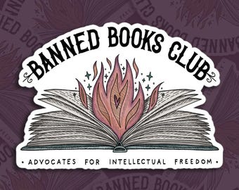 May include: A white sticker with the text "Banned Books Club" in black lettering. The sticker features an open book with flames rising from the center. The text "Advocates for Intellectual Freedom" is printed below the book.