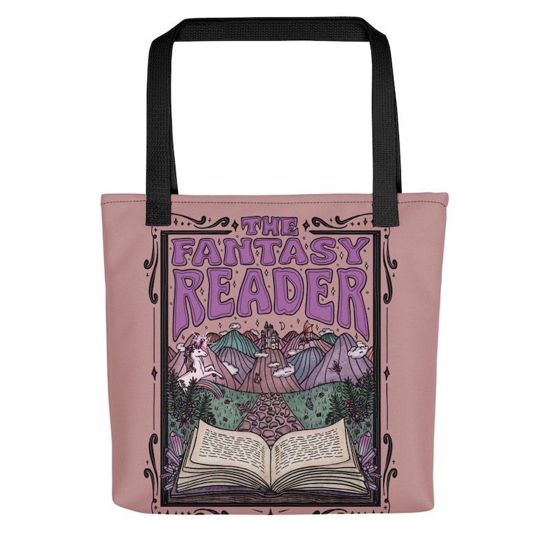 Puede incluir: Una bolsa de tela rosa con una ilustraci&oacute;n caprichosa de un libro, un unicornio y un castillo. El texto "The Fantasy Reader" est&aacute; impreso en morado en la bolsa.