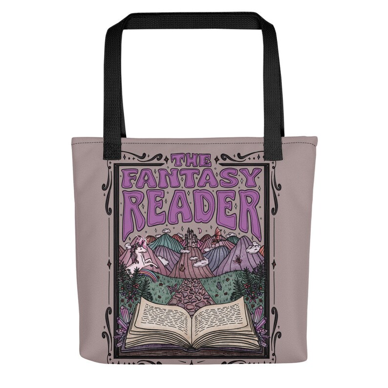 Puede incluir: Una bolsa de tela de color morado con un dise&ntilde;o fantasioso que incluye un libro, un unicornio y un castillo. El texto "THE FANTASY READER" est&aacute; impreso en morado en la bolsa.
