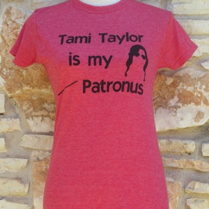 May include: Red t-shirt with black text that reads "Tami Taylor is my Patronus" and a silhouette of a woman with sunglasses.