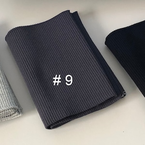 May include: Three different colors of ribbed knit fabric, labeled #5, #9, and #6. The fabric is folded and appears to be a type of elastic knit.