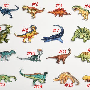 Puede incluir: Un conjunto de 16 parches termoadhesivos con diferentes diseños de dinosaurios. Los parches están numerados del 1 al 16 y son de varios colores, incluyendo verde, azul, naranja, rojo y amarillo.