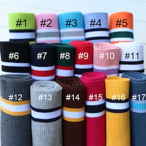 Op de afbeelding: Assortiment van 17 verschillende gekleurde gebreide stof trim met strepen. De trim is geribbeld en heeft een verscheidenheid aan kleurcombinaties. De trim is genummerd van 1 tot en met 17.