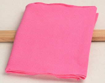 May include: A folded piece of pink ribbed fabric. The fabric has a smooth texture and is perfect for sewing projects.