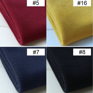 K&ouml;nnte beinhalten: Vier Stoffproben aus Rippstoff in verschiedenen Farben: Rot, Gelb, Dunkelblau und Schwarz. Der Stoff ist gefaltet und die Nummern #5, #16, #7 und #8 sind auf den Stoff geschrieben.