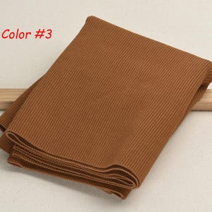 K&ouml;nnte beinhalten: Ein gefaltetes St&uuml;ck braunes Rippgewebe. Farbe #3.