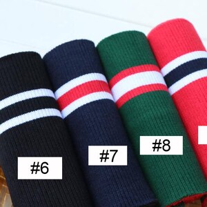 Op de afbeelding: Vier verschillende gestreepte gebreide stoffen met witte strepen en verschillende gekleurde strepen. De stoffen zijn gemarkeerd met #6, #7, #8 en #9.