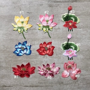 May include: Nine embroidered lotus flower patches in various colours, including yellow, pink, red, blue, and white. Each patch is numbered 1 through 9.