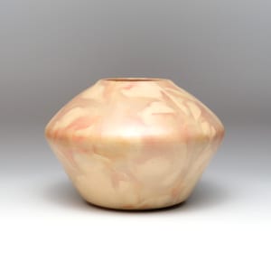 May include: A decorative, hand-turned vase with a unique shape. The vase has a light beige base color with swirling patterns of pink and peach throughout. The opening is a darker shade of brown.