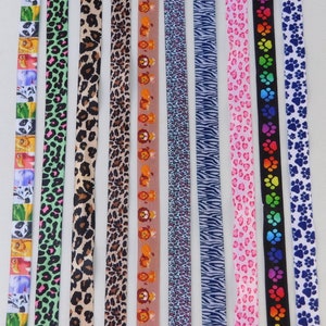 Könnte beinhalten: Zehn verschiedene farbige gemusterte Bandborten. Die Muster umfassen Tierdrucke, Herzen, Pfotenabdrücke und ein Cartoon-Tierdesign.