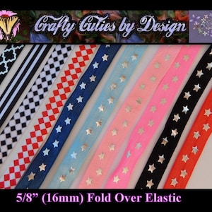 May include: Assortment of 5/8 inch (16mm) fold over elastic with various patterns, including black and white stripes, red and white checkered, blue stars on a navy background, light blue stars on a light blue background, pink stars on a pink background, silver stars on a black background, and silver stars on a red background.