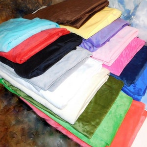 May include: A stack of 18 different colored fabric swatches. The fabrics are folded and stacked on top of each other. The colors include blue, red, black, gray, white, green, and pink.