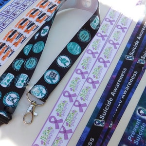 May include: Assortment of colorful ribbon lanyards with various awareness messages, including "Hope Epilepsy", "Suicide Awareness", and "Prevent Suicide".