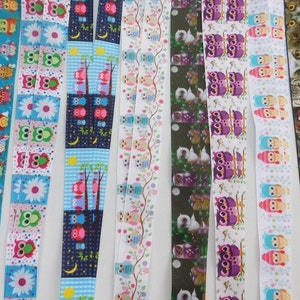 May include: A collection of colorful lanyards with various owl-themed patterns. Designs include owls with flowers, trees, and moons. The lanyards feature a variety of colors, including blue, pink, purple, and green. The lanyards are made of a ribbon-like material.